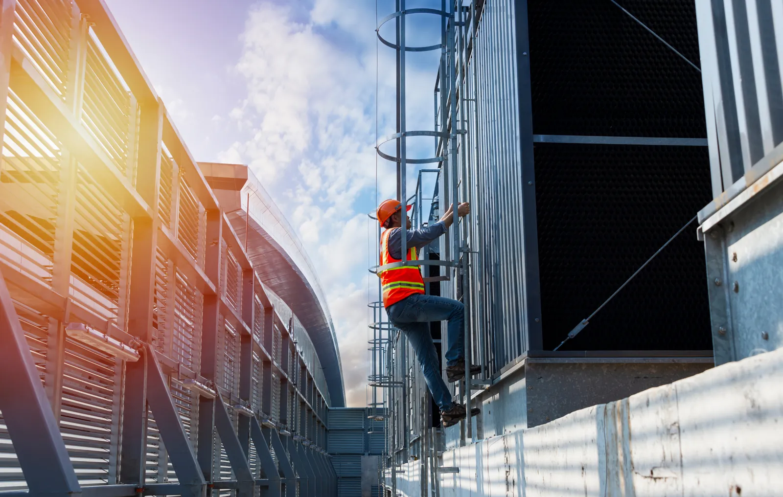Profissional de segurança do trabalho com capacete e colete refletivo inspecionando uma instalação industrial