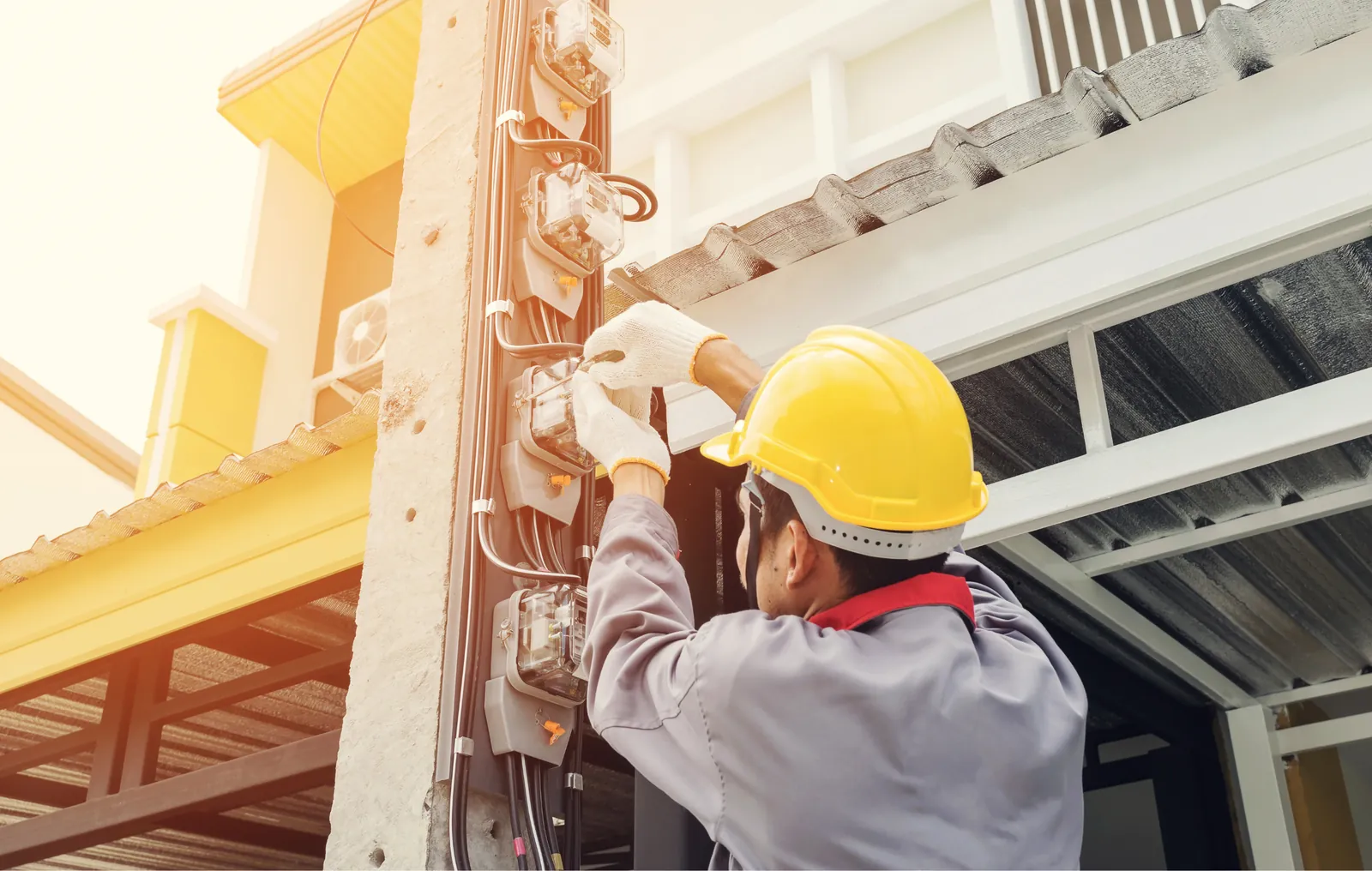 Eletricista realizando intervenção em quadro elétrico com equipamento de proteção